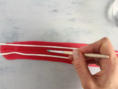 Brushing red fondant with water to stick on cake decorations