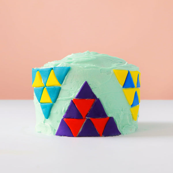 Green mini cake with triangles.
