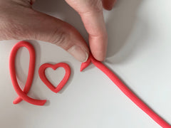 Making fondant letters with red fondant for Valentine's Day decoration