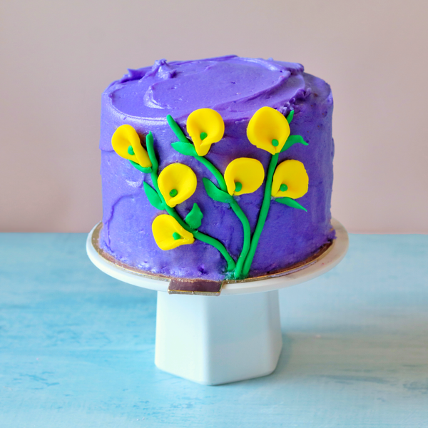 Purple mini cake with yellow calla lilies made from fondant