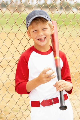 Smiling youth baseball player in a red and white uniform holding a wood baseball bat.