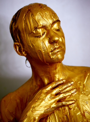 Woman covered in gold pain with eyes closed, for Ivy Leaf Skincare blog