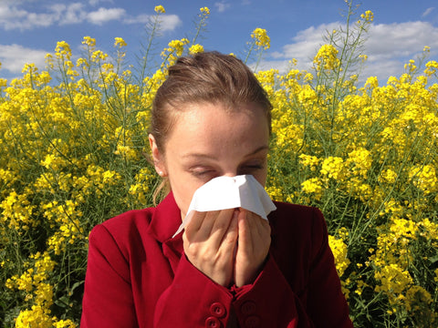 Person in field blowing nose, for Ivy Leaf Skincare blog