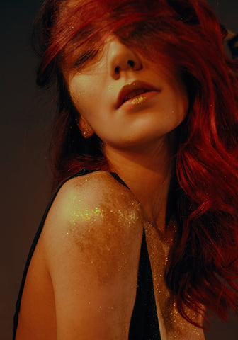 red-haired woman covered in gold dust