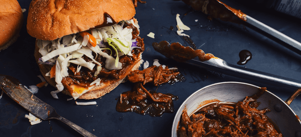 pulled pork burger on a plate with cabbage topping