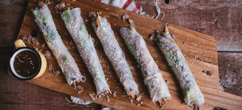 4 spring rolls on wooden plate