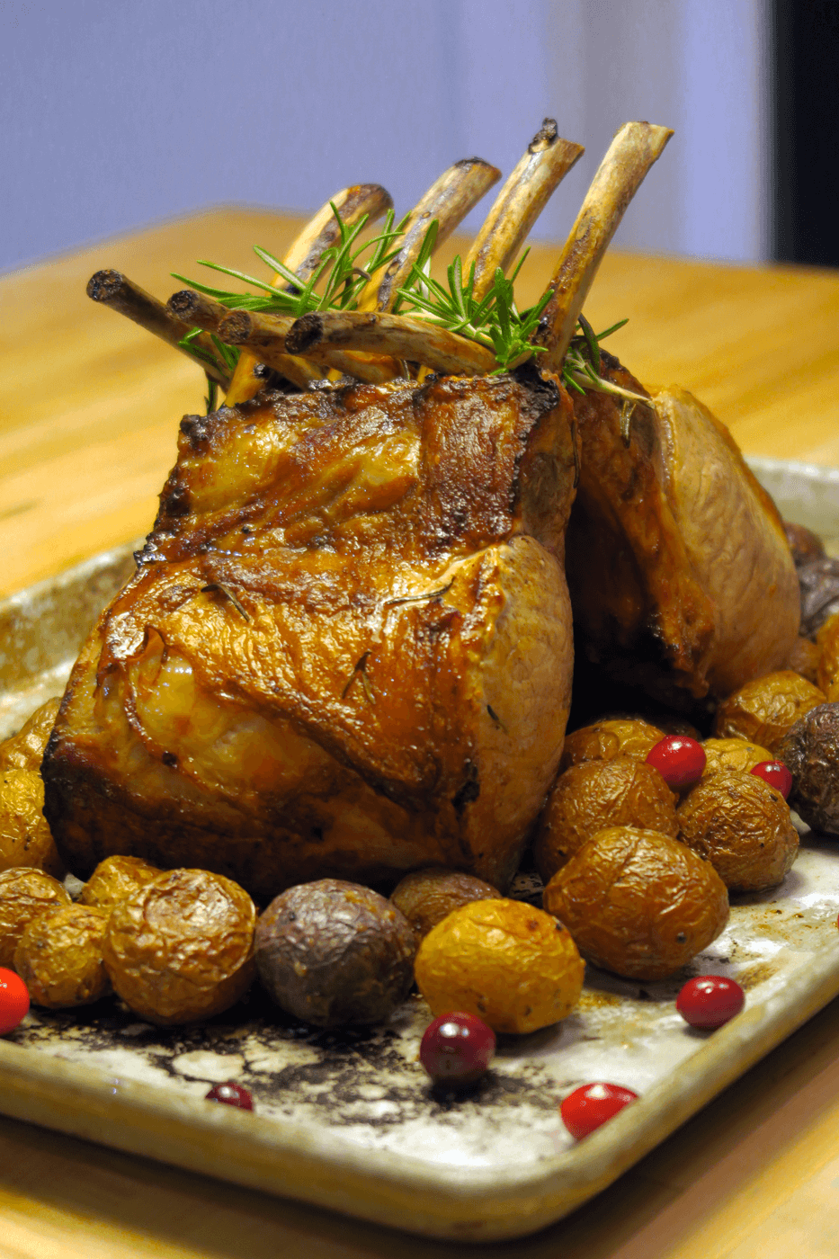 nagano pork rack with cranberries and rosemary sprigs