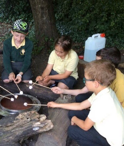 Image of child with Down Syndrome sitting around a campfire with her friends