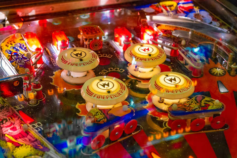 A close-up of the play field of a modern pinball machine with many lights, mechanical parts, and sounds effects.