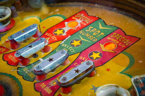 A close-up of the play field of a vintage pinball machine. 