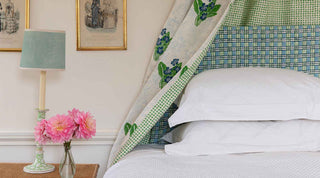 Double bed with head valance in Molly Mahon's Primrose hand block printed fabric with a head board in matching colours Trellis design finished off with a vase of flowers producing a beautiful spring like feel