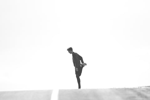 Man Stretching on Road