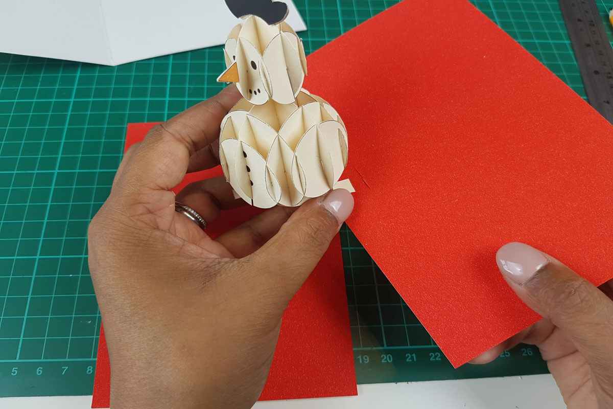 How To Make a 3D Christmas Pop Up Card - picture of slotting the 3D snowman through the cut out slots in the inner cover