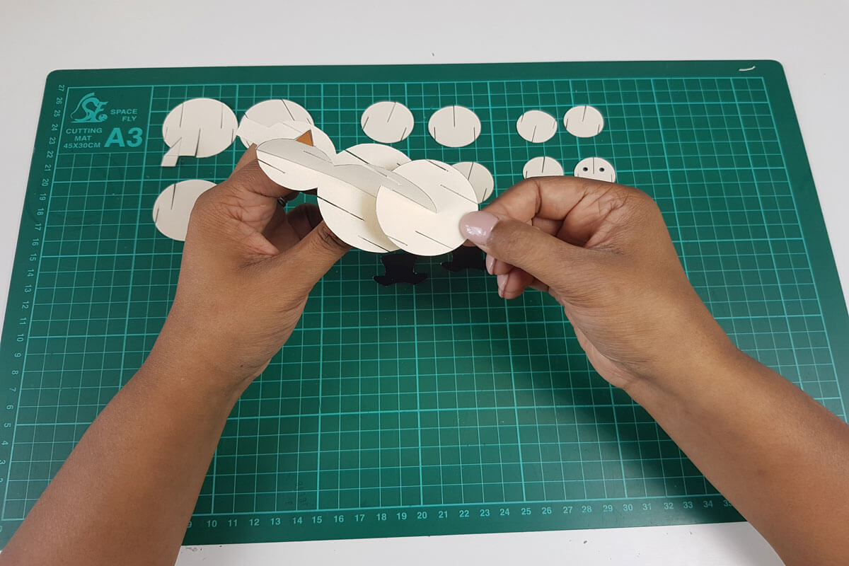 How To Make a 3D Christmas Pop Up Card - picture of slotting the next size of circles to the snowman body
