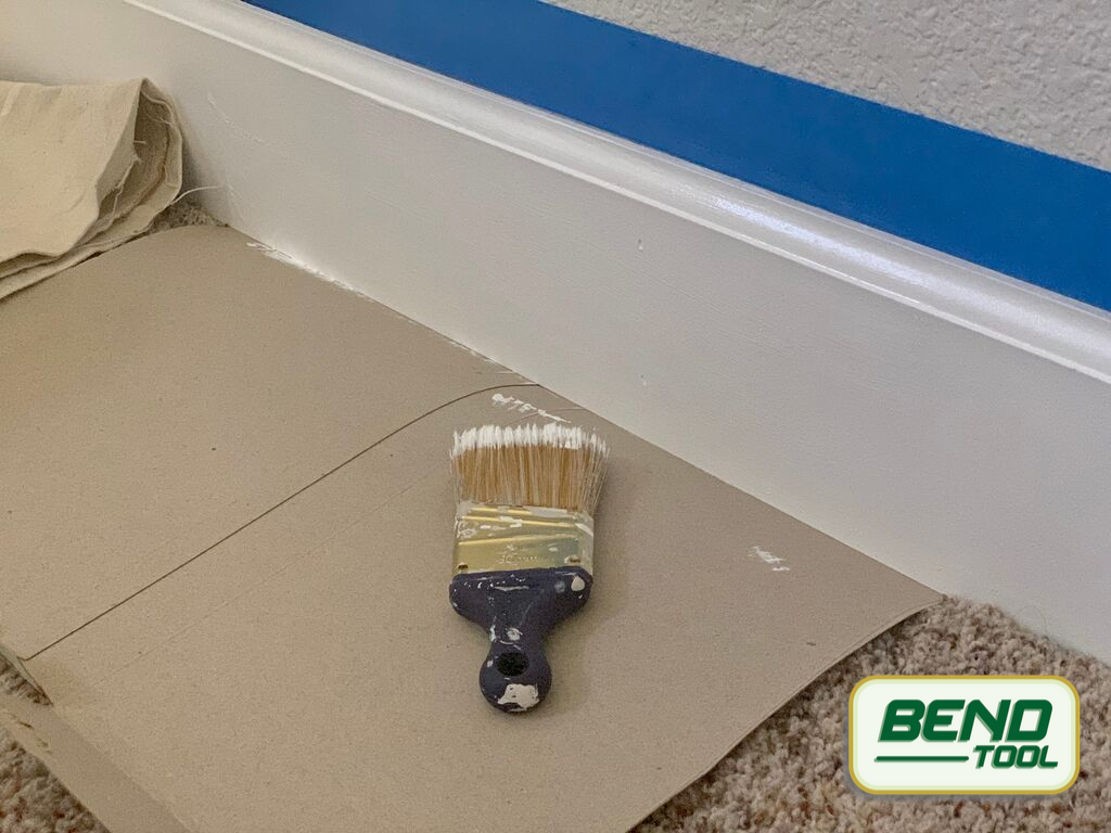 How to paint baseboards with carpet - cardboard protecting carpet, paint brush, painters tape protecting wall