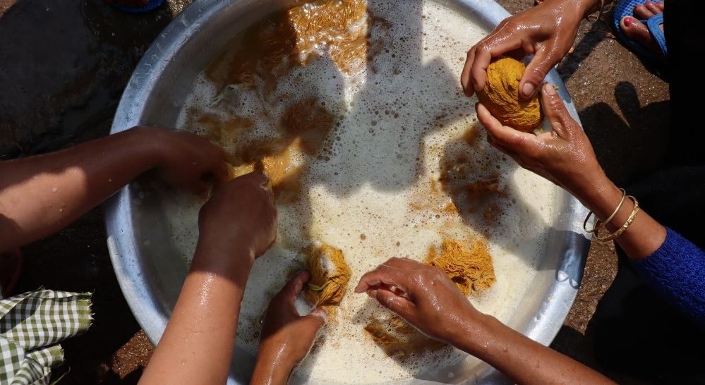 Washing of Eri silk yarns in soap nuts tub | Muezart