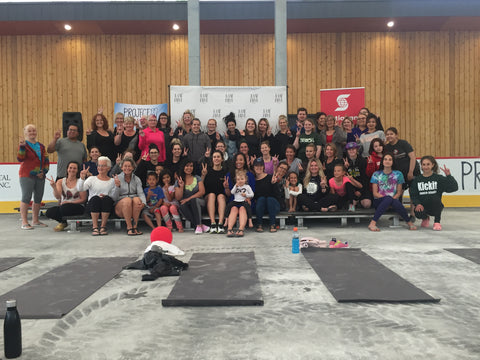 A diverse group of individuals attending a yoga fundraiser at Camp Manitou in support of Project 11