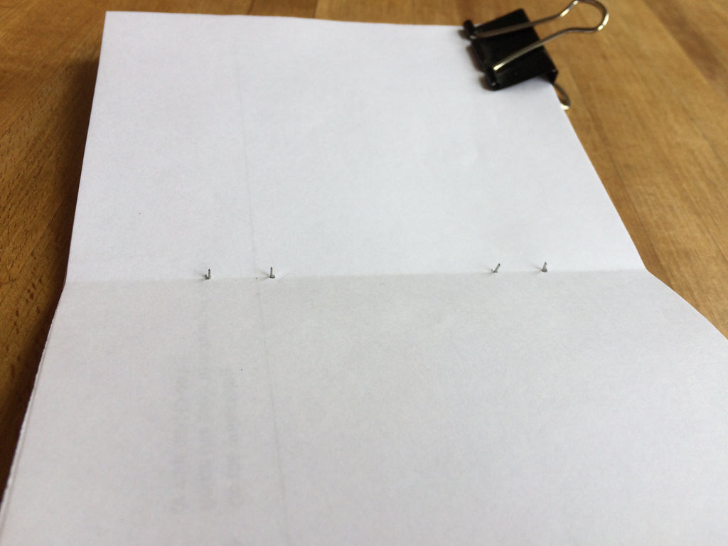 staples sticking out of a stack of paper