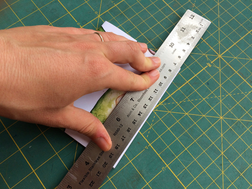 handing holding ruler against edge of notebook