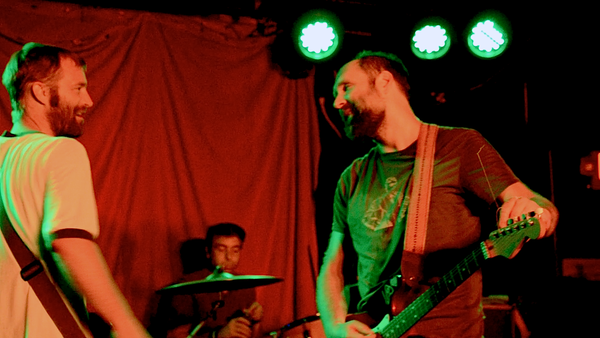 Doug Martsch chats with his bass player on stage with Built to Spill.