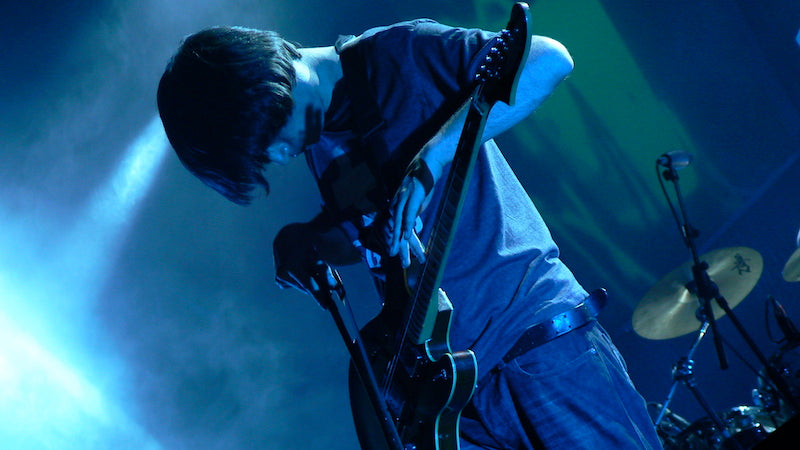 Jonny Greenwood plays his guitar with a violin bow
