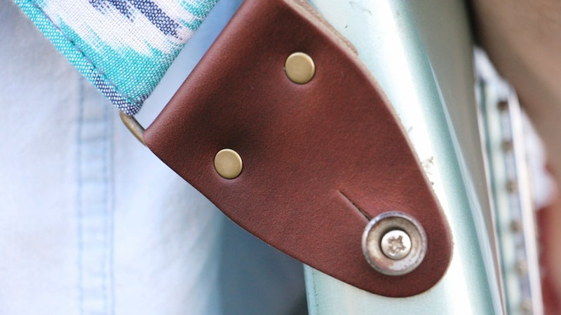 Detail of the Horween leather end tab on the guitar strap we named after David MacNutt