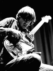 Thurston Moore of Sonic Youth plays guitar with a drum stick.