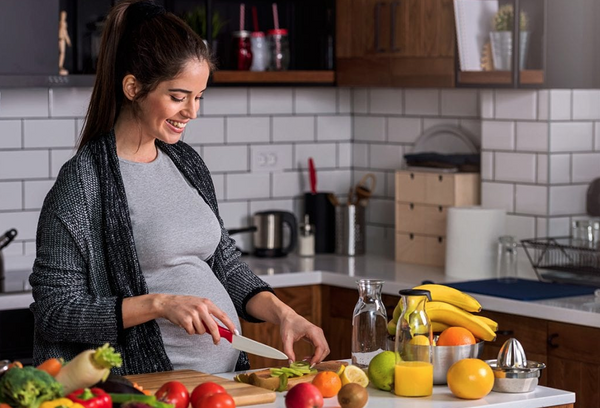 pregnant woman preparing healthy plant-based food