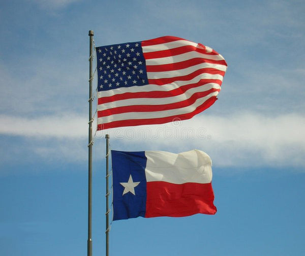 Texas flag flying below US flag