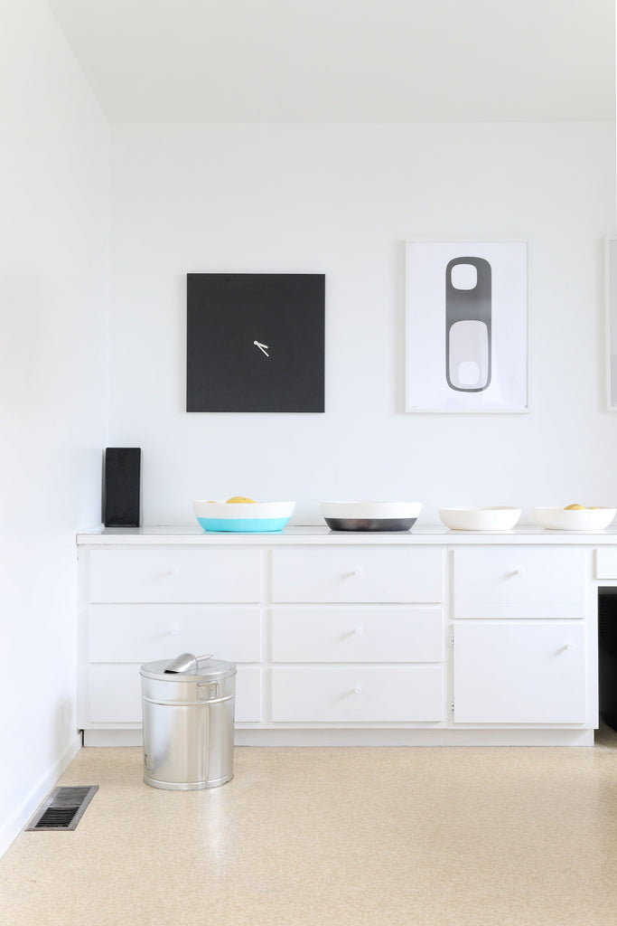 Wall art by designer Tina Frey in 50s-era kitchen with linoleum flooring and dog food storage in Faunamade blog post