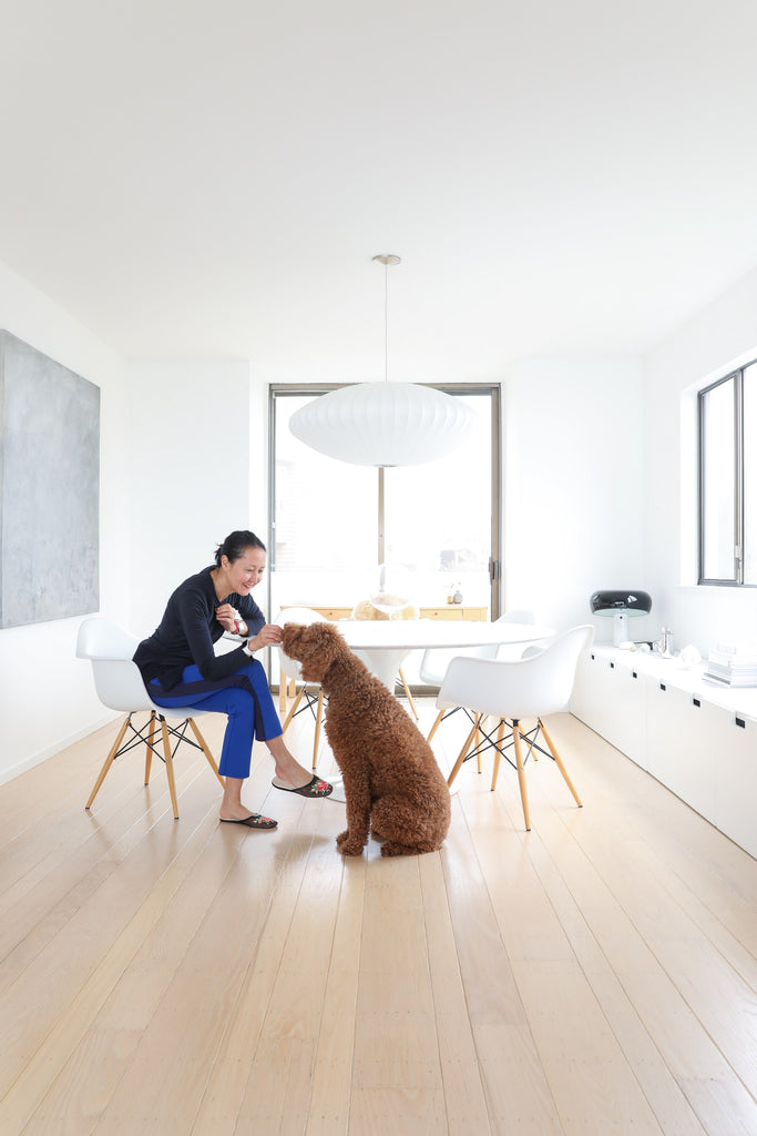 Artist Tina Frey and standard poodle dog in modern dining room on wood floors in Faunamade blog post