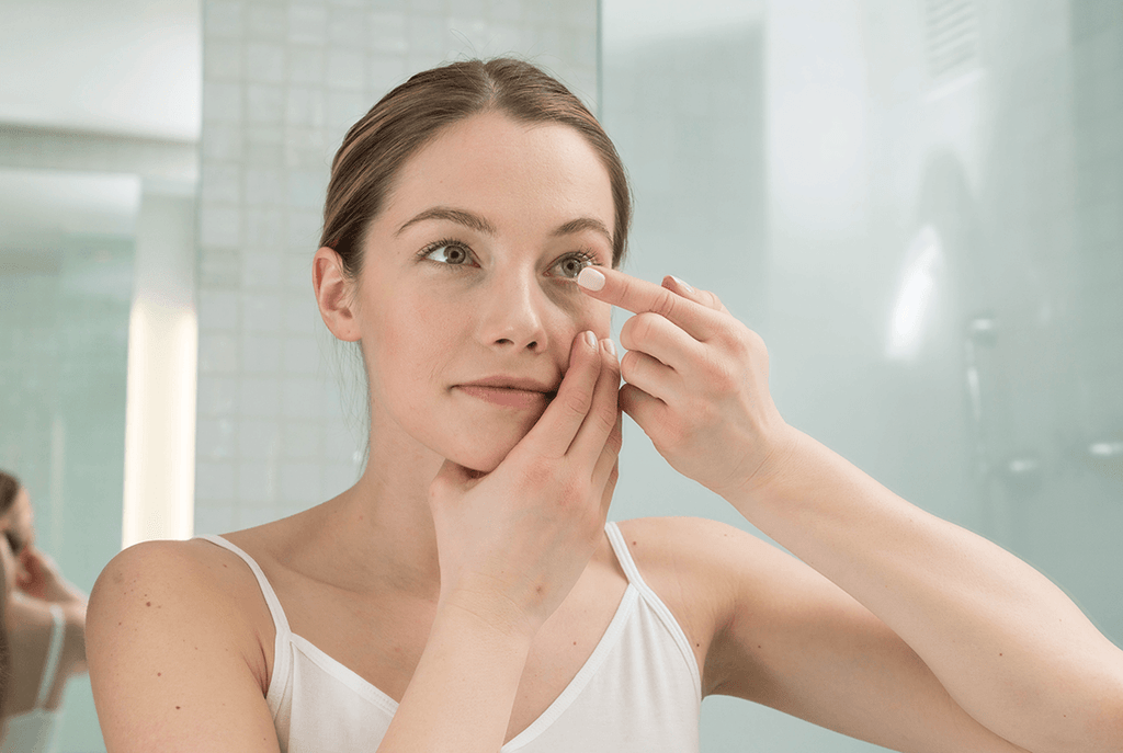 A girl putting prescription contact lenses on