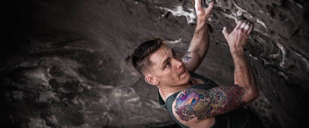 Chris Simmons Bouldering and showing off his Tattoo