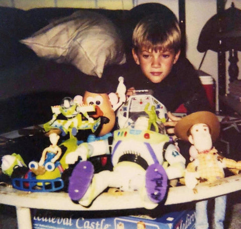 Young boy sitting in front of a bunch of toys