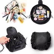 A drawstring cosmetic bag in black. There are skin products and makeup inside the bag.