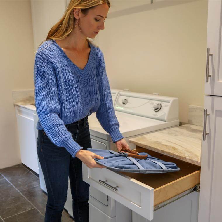 woman storing the Laundry Caddy LUXE in a drawer