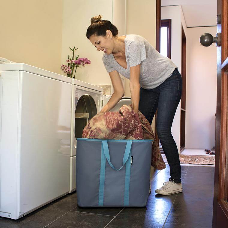 woman filling the Laundry Caddy with clean blankets