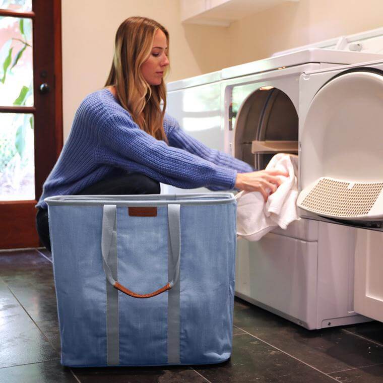 woman emptying clean laundry from dryer into a Laundry Caddy LUXE