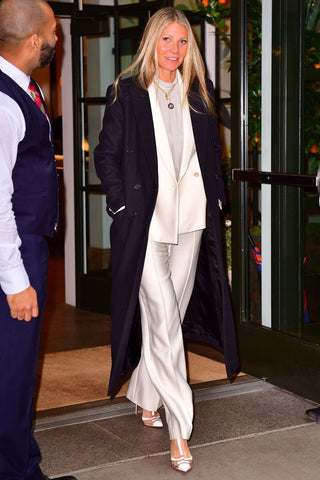 Gwyneth Paltrow wearing a white silky suit 