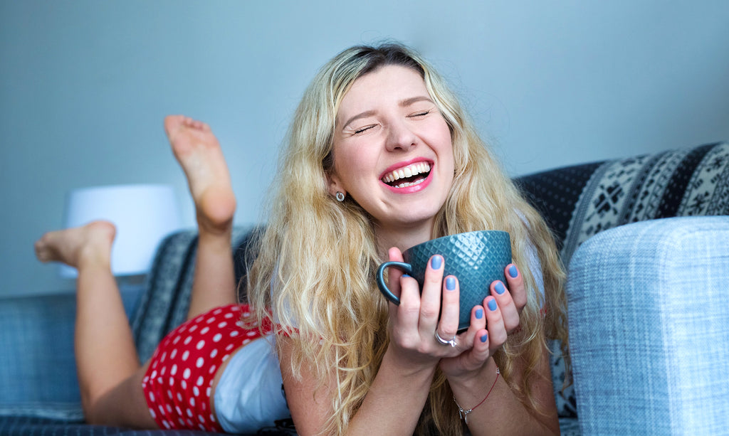 happy woman with light blue fingernails and cup
