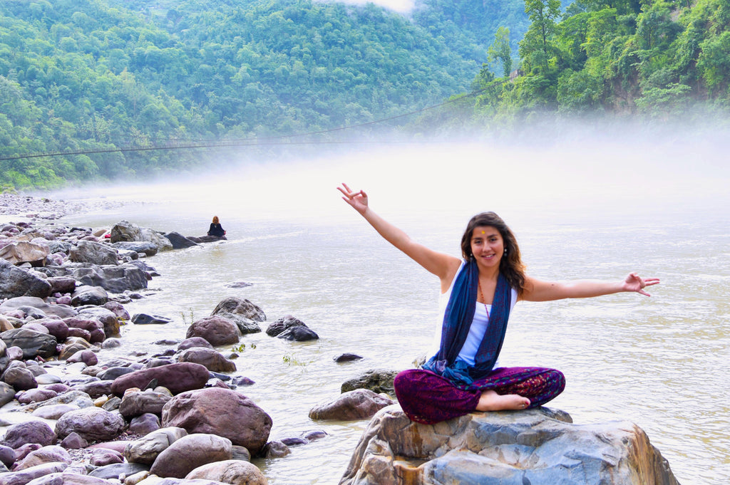 happy young woman on rock in misty stream