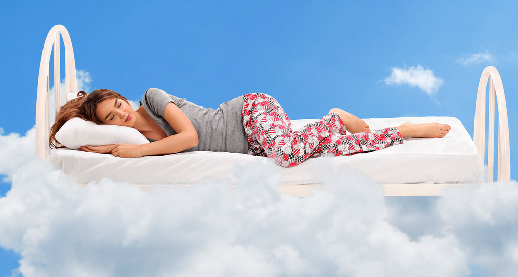 girl sleeping happily on a bed in the clouds