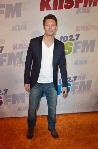 Ryan Seacrest wearing medium blue jeans