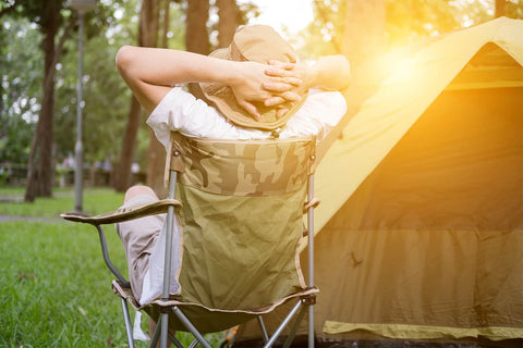 A man sat in a camping chair outside