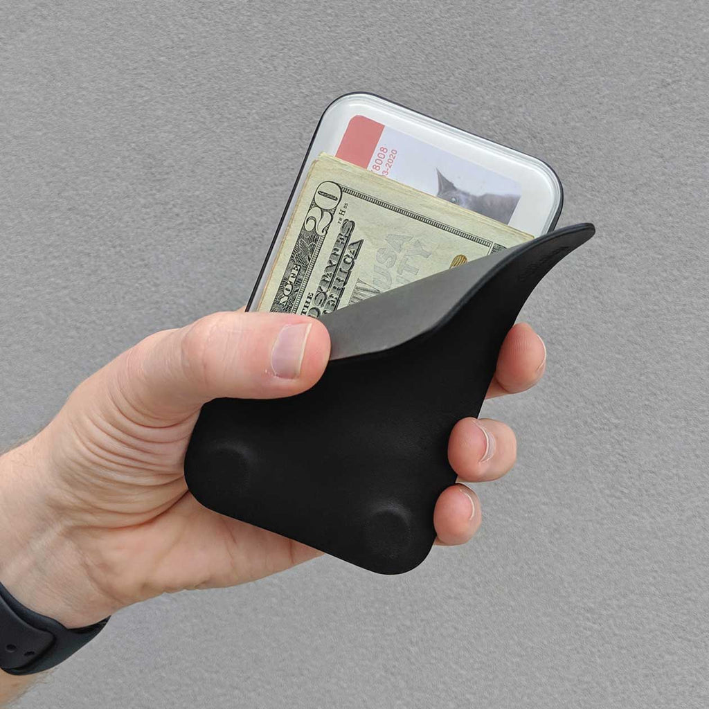 right thumb revealing the contents inside the distil modwallet - folded $20 USD and cards