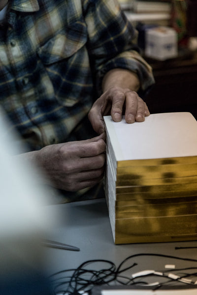 Book mark being hand glued onto the spine of the notebook