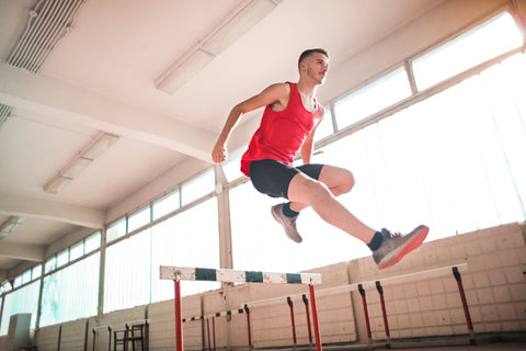 An image of a man jumping over a hurdle. 