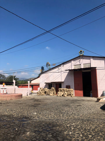 Coffee bags stacked in front of Bella Vista Mill in Antigua, Guatemala