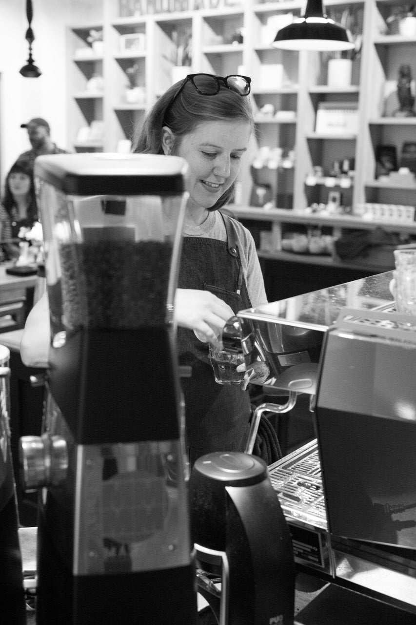 Accounts manager for Kuma Coffee smiling while making espresso on a La Marzocco Machine