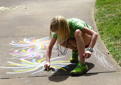 Child drawing sidewalk chalk